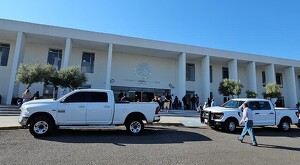 Vista exterior de los juzgados de juicio oral de Puente Grande Jalisco con camionetas blancas y diversas personas alrededor