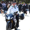 En la imagen se ve a un oficial de tránsito vestido de blanco con negro en una motocicleta y a lo lejos se ven más elementos de seguridad.