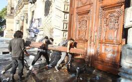 Hombres golpean puerta de madera con objeto