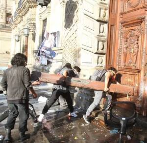 Hombres golpean puerta de madera con objeto