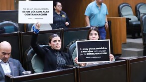 Claudia Caballero con pancarta reclamando por contaminación en Congreso de Nuevo León.