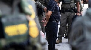 Elementos de la Policía de Chicago realizando la detención de un hombre de 40 años con esposas colocadas y las manos en la espalda