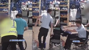 Hombre de playera gris en una silla de ruedas y otro de playera azul