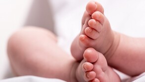 Se ven unos pies de un bebé recién nacido con fondo blanco.