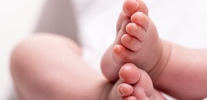 Se ven unos pies de un bebé recién nacido con fondo blanco.
