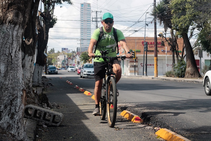 Persona circulando en una ciclovía en calles de Puebla.