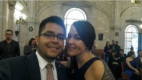 Hombre se piel morena clara y lentes y mujer piel morena clara, trenza y vestido negro