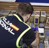 Elemento de la Policía Nacional de España frente a varios paquetes de droga que fueron incautadas durante el operativo internacional