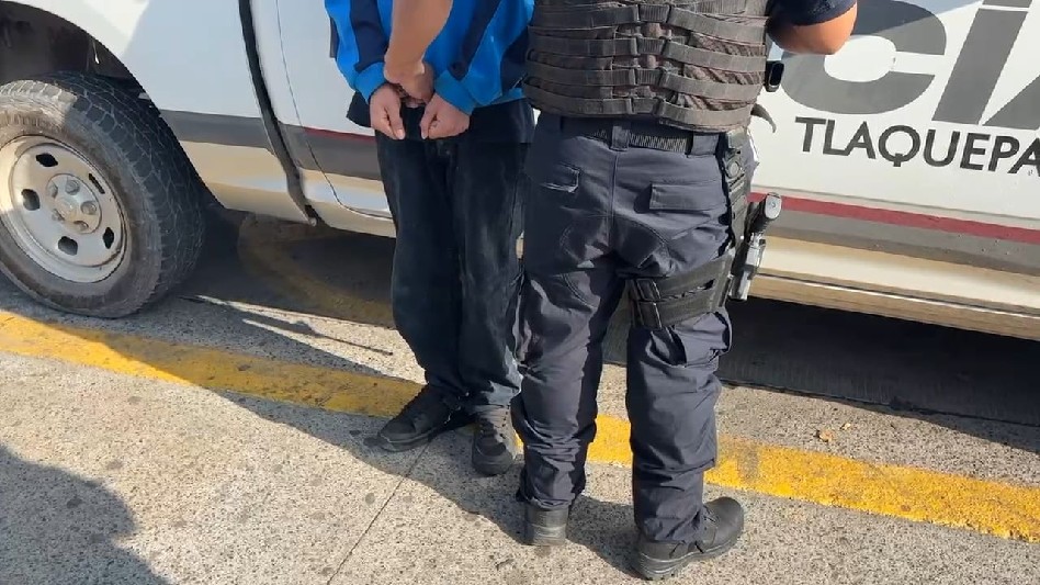 Elemento de la Policía de Tlaquepaque realizando el arresto del joven de 18 años a un lado de una patrulla