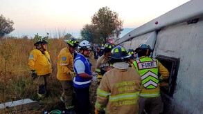 Elementos de Protección Civil y Bomberos de Michoacán al lado del techo del camión volcado sobre la carretera Morelia–Pátzcuaro