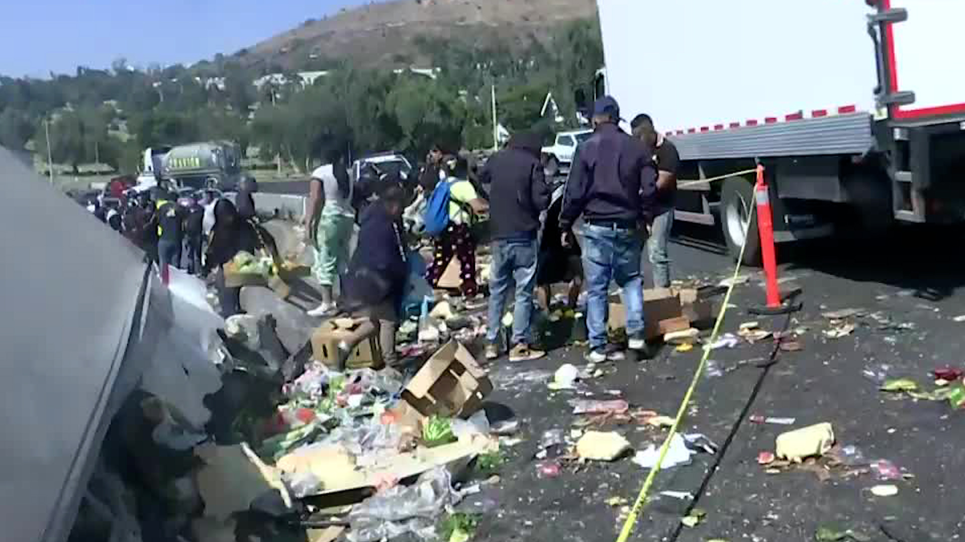 El vehículo transportaba frutas, verduras y yogurt que fueron tomadas por vecinos de la zona. Policías laboran en la zona.