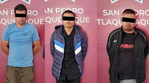 Tres hombres detenidos, con los ojos censurados y las manos en la espalda frente a una pared rosa de la Comisaría de Tlaquepaque