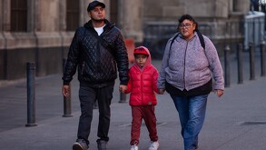 Familia caminando al aire libre en calles de la Ciudad de México.