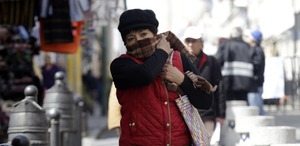 una mujer abrigada y cubierta de la cara por el frente frío en puebla