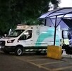 Vista lateral de una ambulancia de la Cruz Verde Las Águilas en Zapopan estacionada al exterior del hospital de noche con motos a los lados
