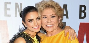 Aislinn Derbez sonriente junto a su madre, Gabriela Michel. Ambas miran a la cámara mientras se abrazan.