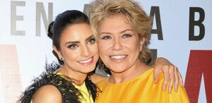 Aislinn Derbez sonriente junto a su madre, Gabriela Michel. Ambas miran a la cámara mientras se abrazan.
