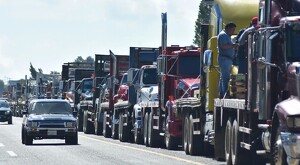 Fila de tráileres estacionados en carreteras de Jalisco con autos pasando a un costado