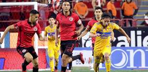 Diego Lainez conduciendo el balón en el Estadio Caliente durante un partido de Xolos vs Tigres en 2024.