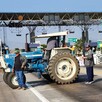 Tractor azul en medio de la carretera bloqueando casetas de Michoacán con agricultores manifestantes alrededor