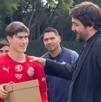 El dueño de Chivas, Amaury Vergara (a la derecha, de traje oscuro), pone la mano en el hombro del futbolista Jesús 