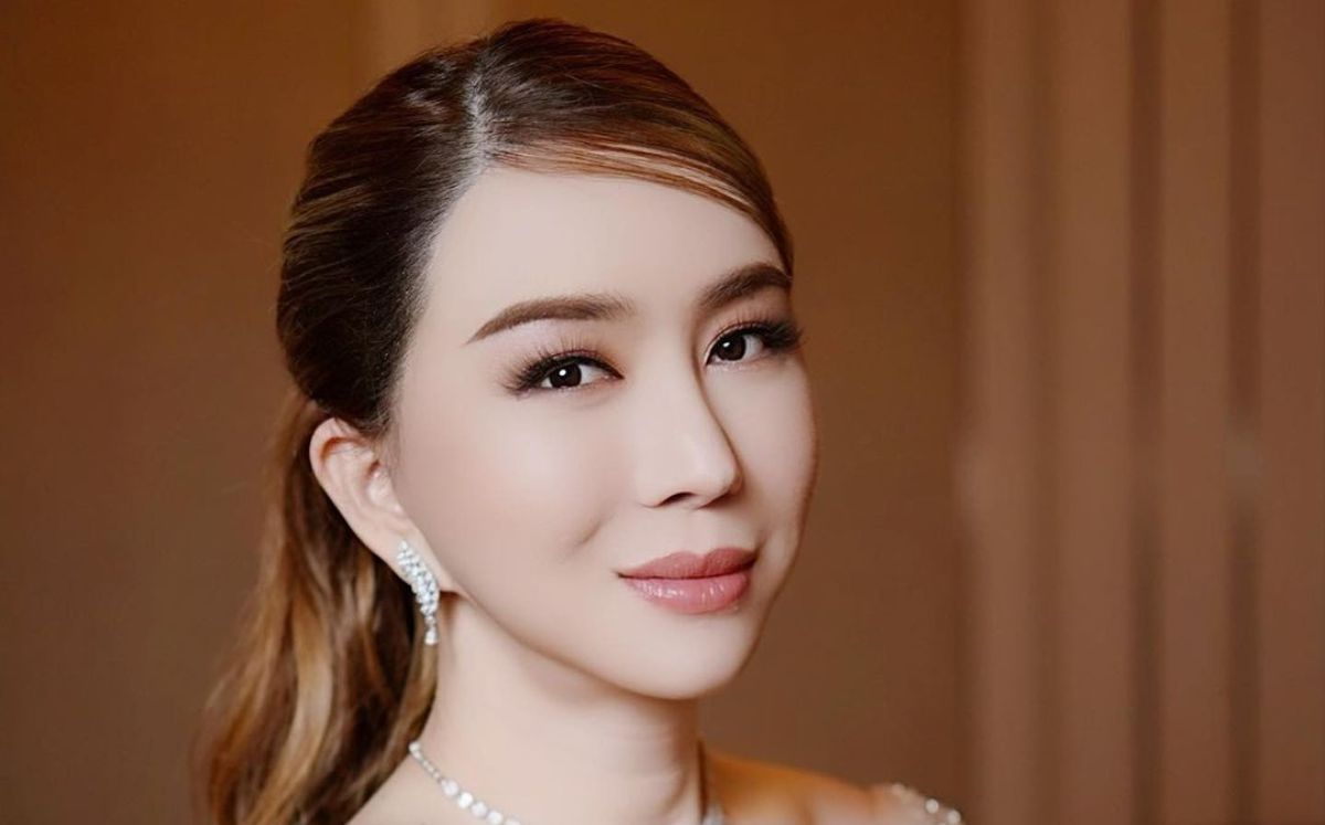 Anne Jakrajutatip con aretes plateador y peinado con copete