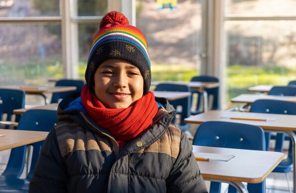 Aula vacía y un niño abrigado por las condiciones climáticas que se esperan por el  frente frío número 13 en Puebla.