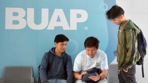 Tres jóvenes dialogando en uno de los edificios de la BUAP, en Puebla.