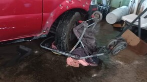 Una niña con su carriola se quedó debajo de la llanta de una camioneta color rojo al interior de un domicilio.