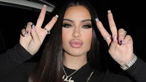 Maria de la Rosa portando un atuendo en color negro y haciendo señas con sus manos.