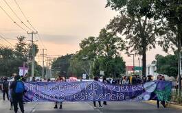 Grupo de mujeres marchando con un cartel y consigna