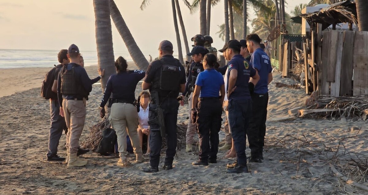 Oficiales de diversas dependencias de Michoacán en medio de la Playa Jardín rodeando a compañeros del estudiante desaparecido