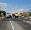 Una carretera en un día soleado, donde múltiples tráileres y camiones de carga están detenidos y bloqueando todos los carriles.