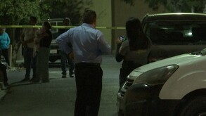 Se observa mucha gente en la calle y una cinta amarilla de precaución.