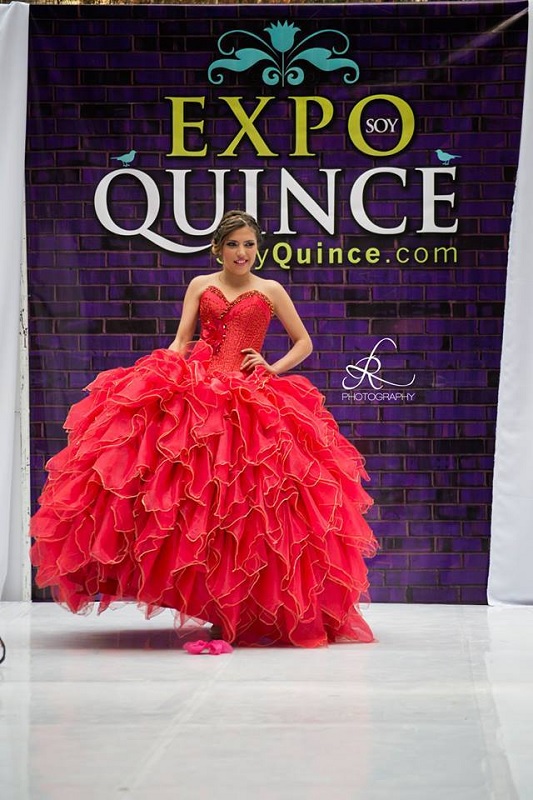Una mujer con vestido de quinceañera posando.