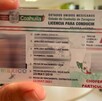 Se observa en la imagen una mano que agarra una licencia de conducir.