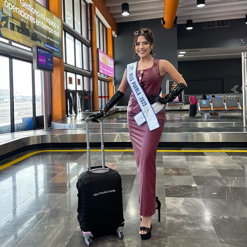 Una mujer con vestido y tacones, junto a una maleta de viaje.