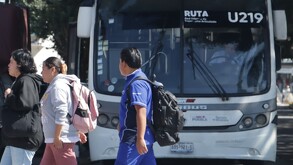 Personas caminando frente a una unidad de RUTA en Puebla.