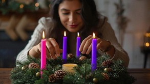 una mujer adornando una corona de adviento