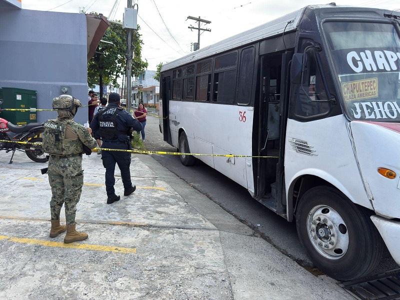Policía y elementos del Ejército resguardan un autobús de pasajeros.