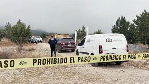 Se observa un terreno y una camioneta blanca que dice funerarias Martínez, además hay una cintilla amarilla de prohibido el paso.