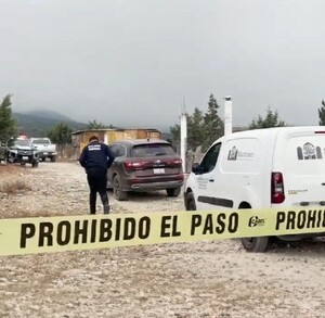 Se observa un terreno y una camioneta blanca que dice funerarias Martínez, además hay una cintilla amarilla de prohibido el paso.