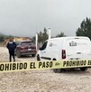 Se observa un terreno y una camioneta blanca que dice funerarias Martínez, además hay una cintilla amarilla de prohibido el paso.