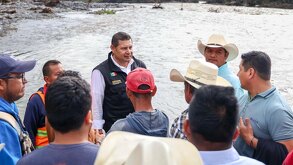 Grupo de personas frente a un río desbordado en Jopala, Puebla.