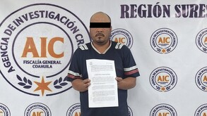 Se observa a un hombre parado y al fondo se ve una lona que dice Agencia de Investigación Criminal.