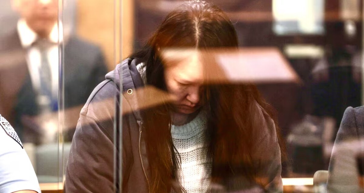 Madre identificada como Hakyung Lee, mostrándose cabizbaja detrás de un cristal de seguridad durante el juicio en una corte de Nueva Zelanda