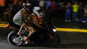 Dos personas a bordo de una motocicleta.