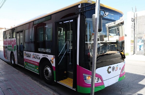 En la imagen se ve un camión de transporte público blanco con asientos.