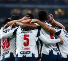 Jugadores de Rayados abrazados tras la segunda anotación.