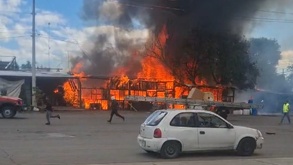 Personas corriendo cerca de un incendio en San Martín Texmelucan, Puebla.